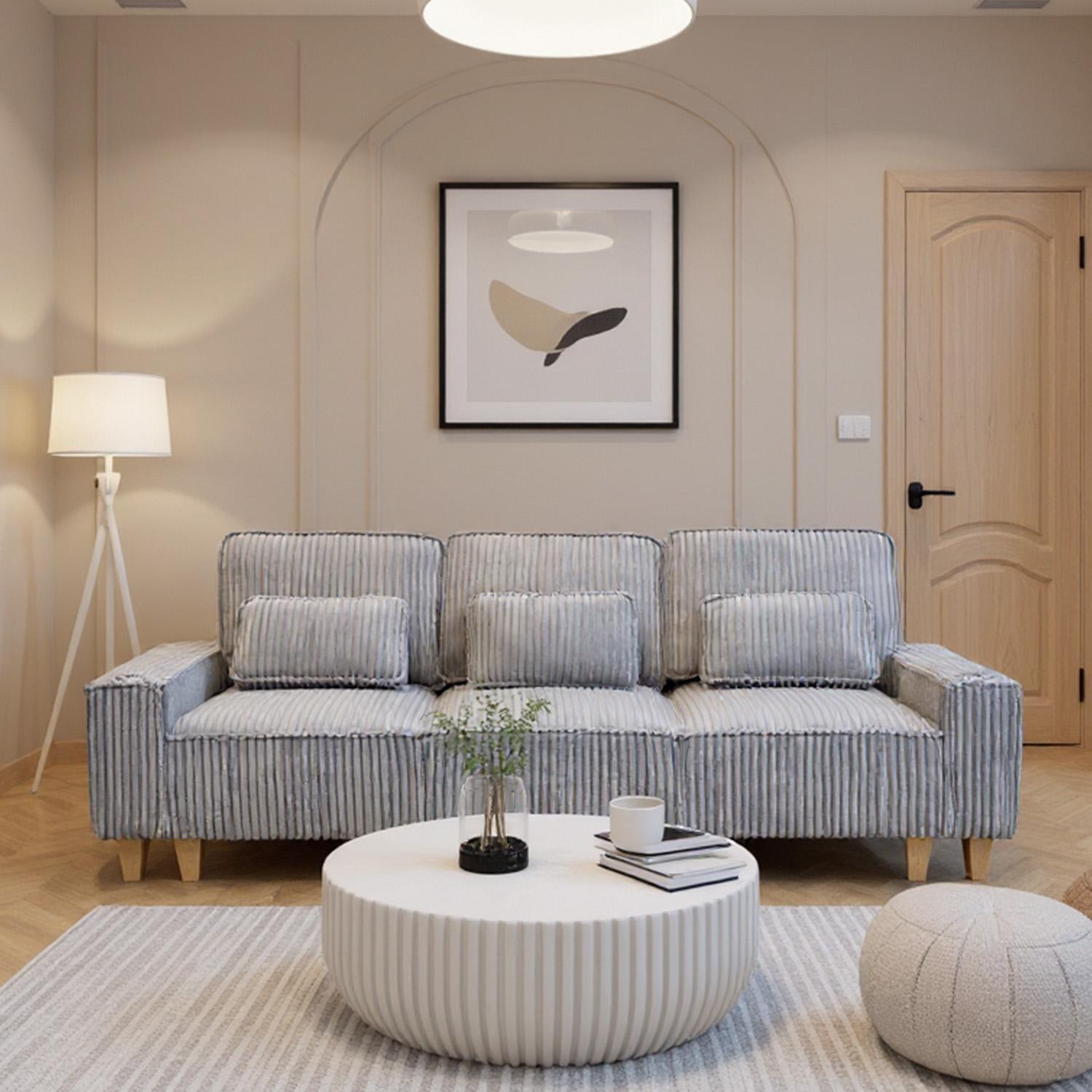 Modern living room with a striped sofa, round coffee table, and decorative elements.